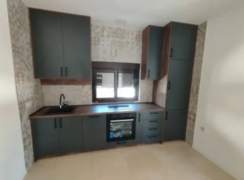 Modern kitchen with dark cabinetry and a built-in oven. - image 7