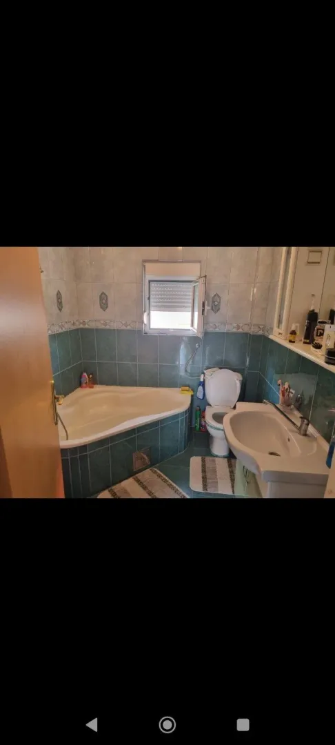 Bathroom with a corner bathtub and tiles.