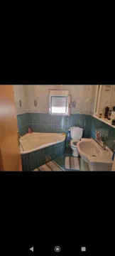 Bathroom with a corner bathtub and tiles. - image 2
