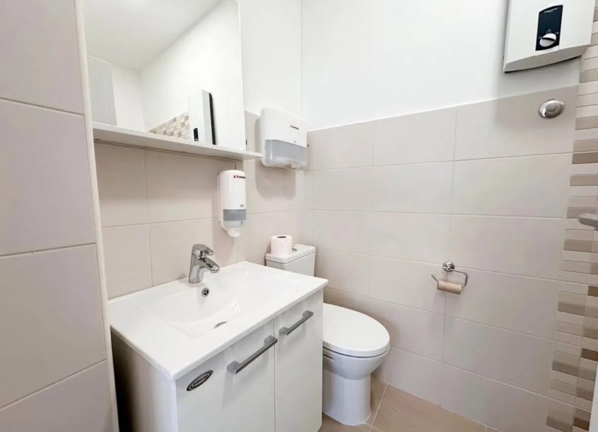 Small bathroom with sink, toilet, and mirror.