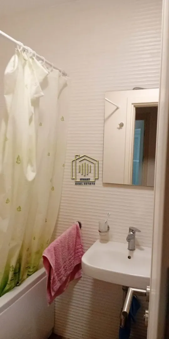 Manje kupatilo sa kadom, umivaonikom i ogledalom.
