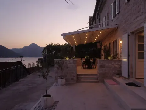 View of the exterior of the house and terrace at dusk with a sea view. - image 7