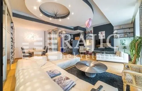 Spacious and modern living room with a sofa and a dropped ceiling.