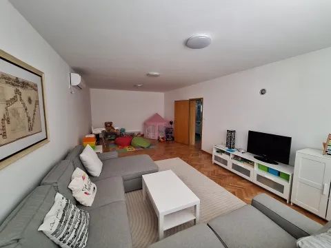 Prostrana dnevna soba sa ugaonom garniturom, TV komodom i delom za igru. - image 10
