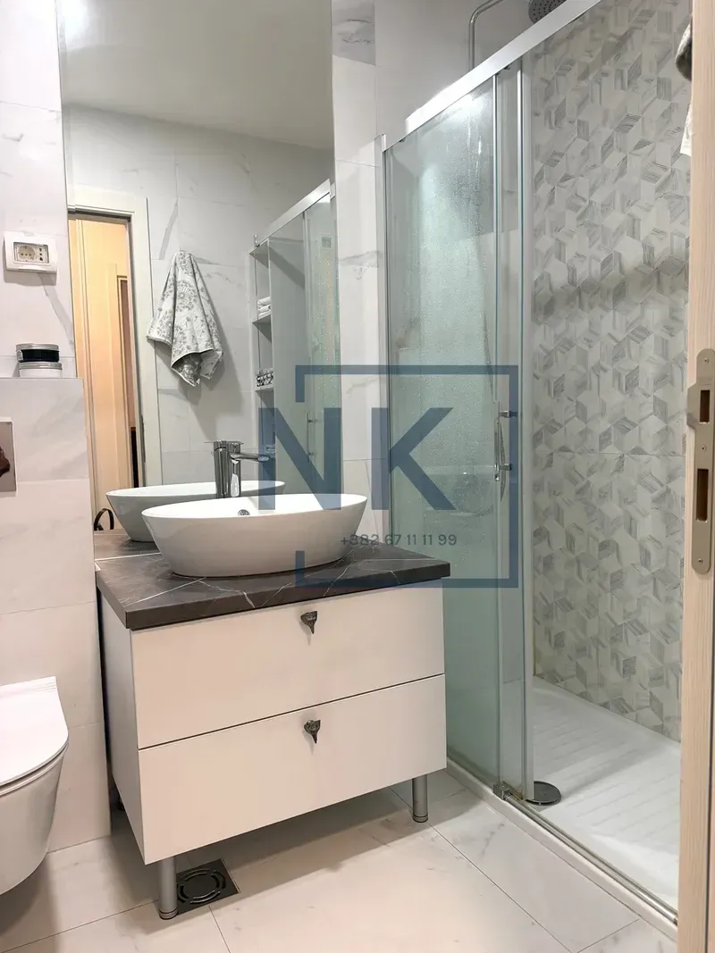 Moderne kupatilo sa tuš kabinom i umivaonikom.
