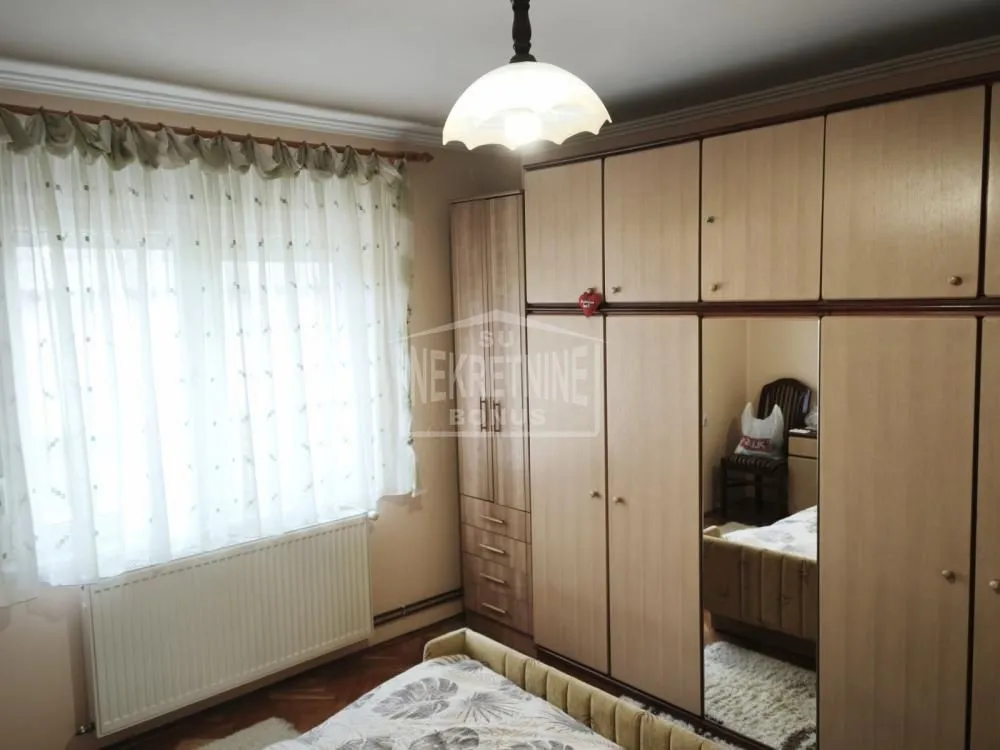 Nameštena spavaća soba sa velikim garderoberom i krevetom.