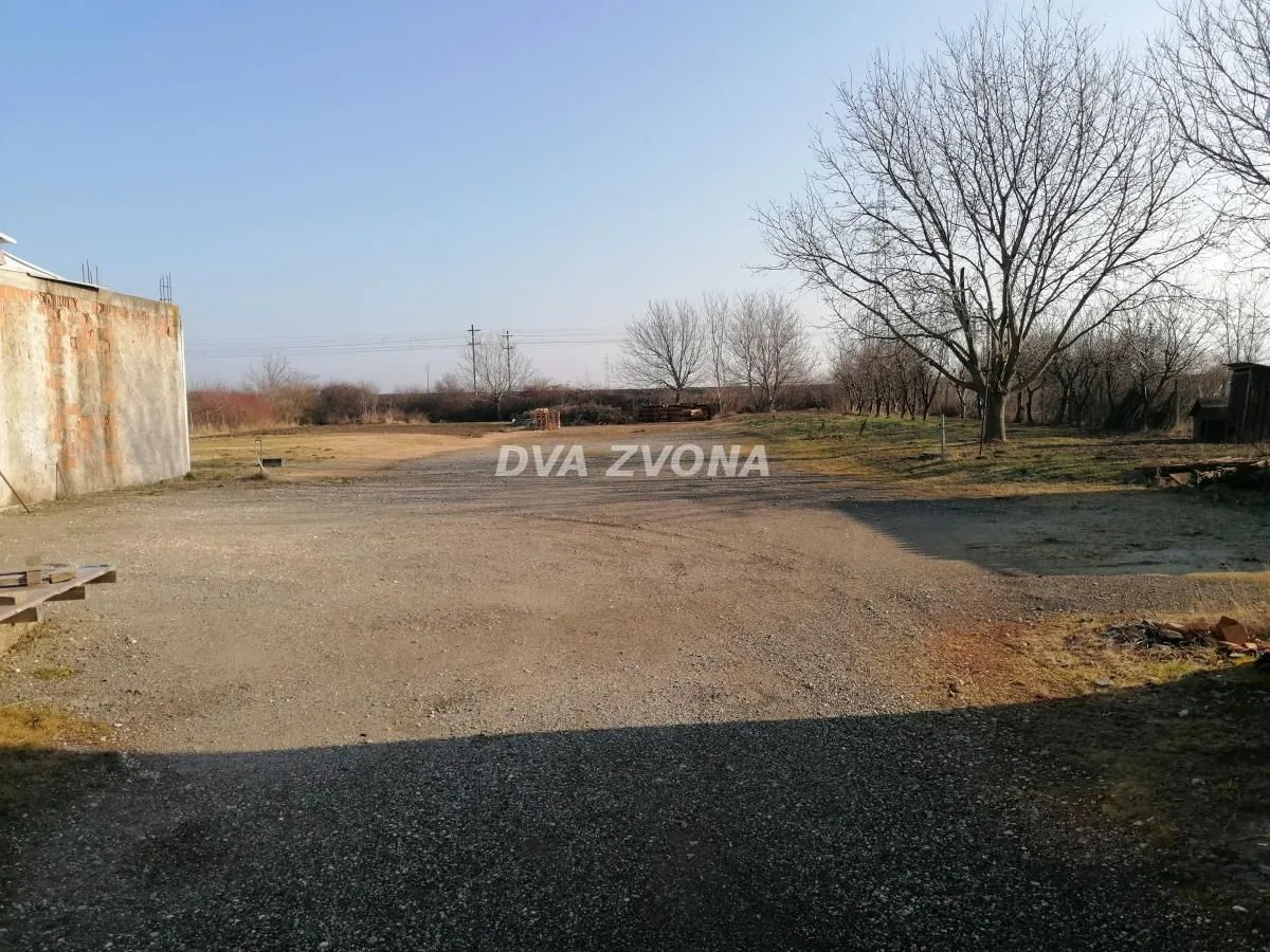 View of the spacious yard and surrounding landscape with trees.