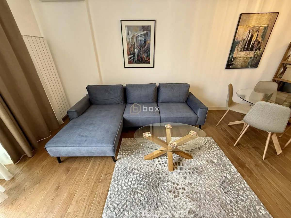 Living room with a grey corner sofa and a dining table.
