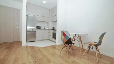 Small bright kitchen with a dining table and chairs. - image 4