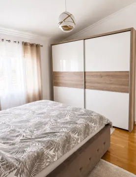 Bright bedroom with a double bed and a large wardrobe. - image 18