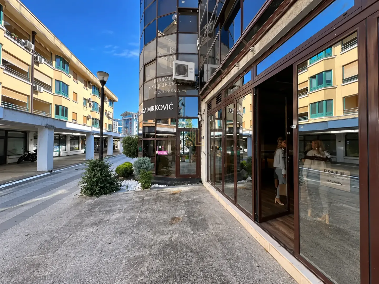 Exterior view of the commercial space and a building with a glass facade.