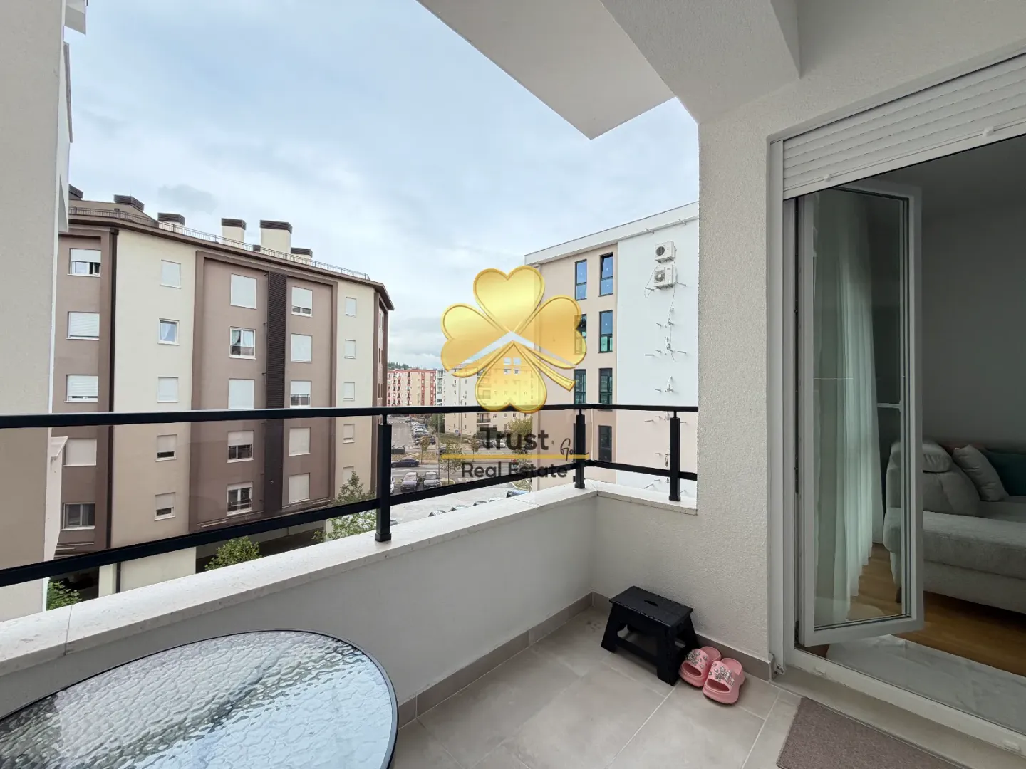 Manji namješteni balkon sa pogledom na okolne zgrade.