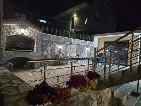 Night view of the courtyard with a stone barbecue, terrace, and stairs. - image 11