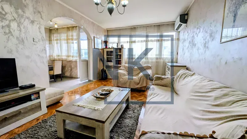 Living room with sofa set, TV cabinet, and access to the terrace.