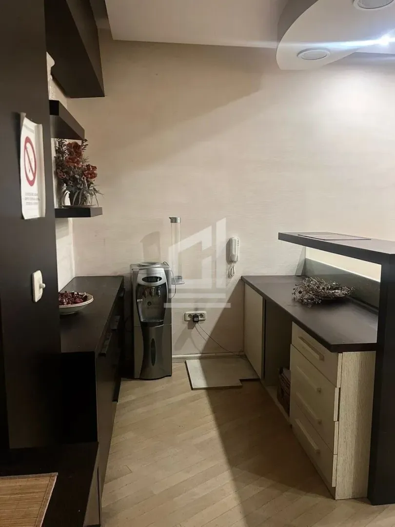 Small kitchen with dark and light cabinetry and a water dispenser.