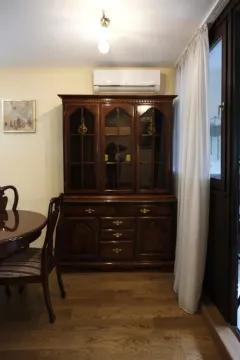 Part of a room featuring a large wooden cabinet and a dining table. - image 2