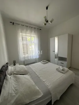 Bright bedroom with a double bed, wardrobe, and a window. - image 11