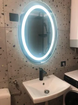 Bathroom with a washbasin and an illuminated mirror. - image 12