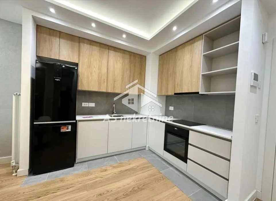 Modern kitchen with fitted units and a black refrigerator.