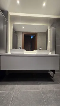 Modern bathroom with two washbasins and a large mirror. - image 9