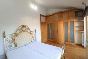 Spavaća soba sa bračnim krevetom i drvenim ormanom. - image 24