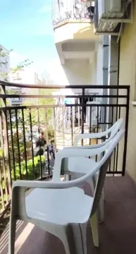 Smaller furnished balcony with chairs and street view. - image 8