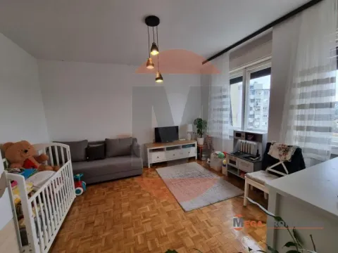 Living room with a sofa, TV, and a baby crib. - image 5
