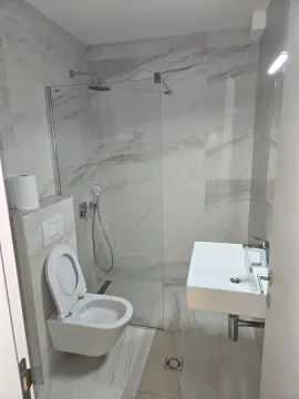Modern bathroom with a shower cabin and white tiles. - image 5