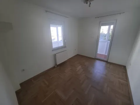Prazna soba sa parketom, prozorom i balkonskim vratima. - image 6