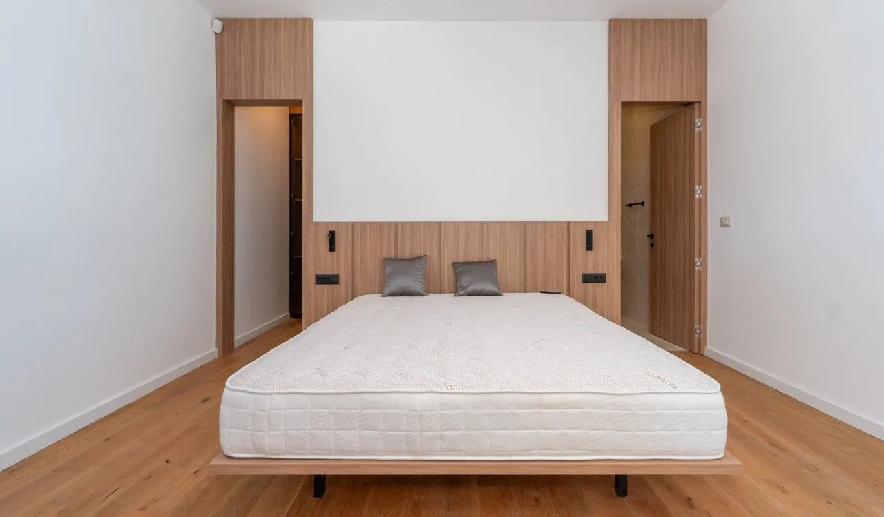 Bedroom with a double bed and wooden wall paneling.