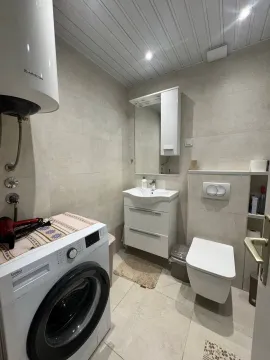 Smaller bathroom with washing machine, washbasin and toilet. - image 2