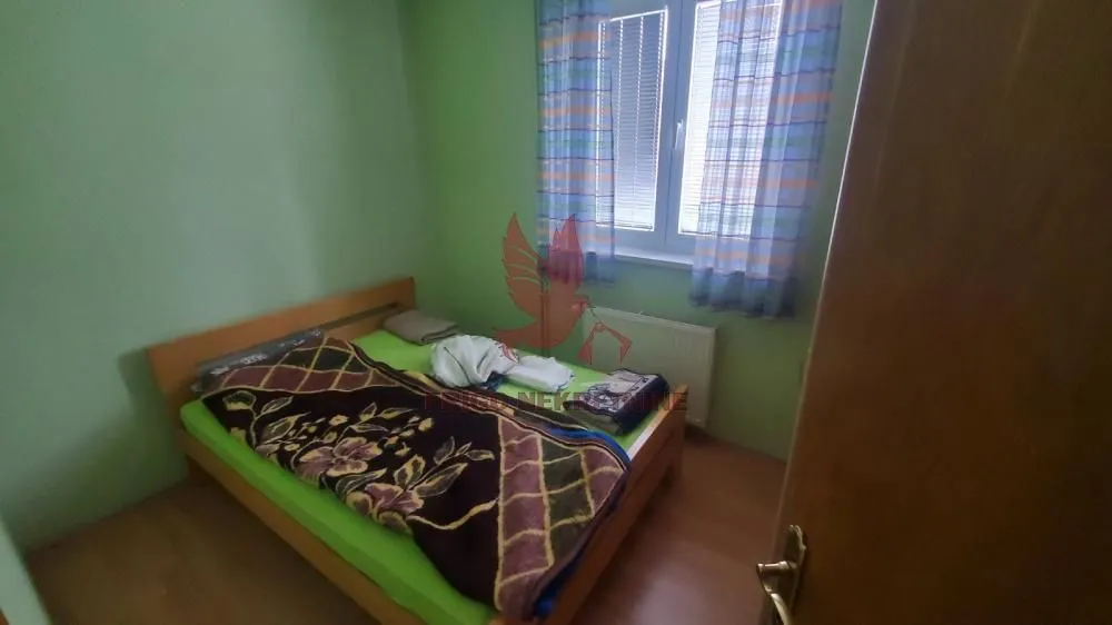 Manja spavaća soba sa bračnim krevetom i prozorom.