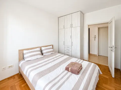 Furnished bedroom with a double bed, wardrobe, and wooden flooring. - image 3