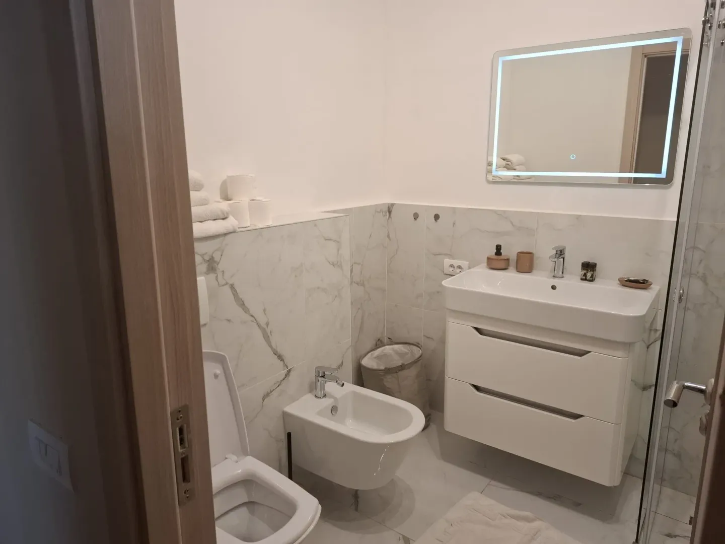 Moderno opremljeno kupatilo sa umivaonikom, wc šoljom i bideom.