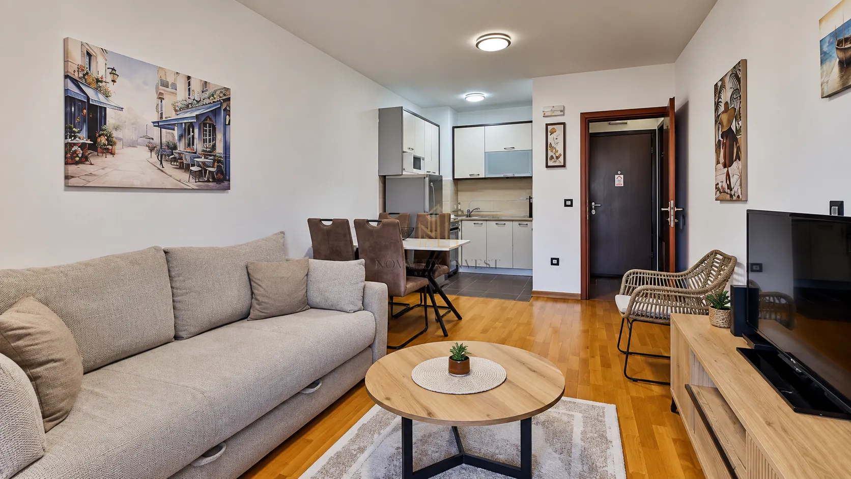 Living room with sofa, TV, and an adjoining dining area.