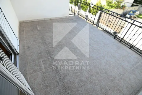 Spacious tiled terrace with a metal railing and a view of the courtyard. - image 38