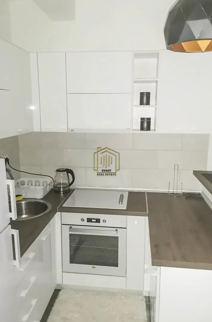 Small white kitchen with a built-in oven and hob.