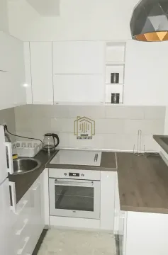 Small white kitchen with a built-in oven and hob. - image 3