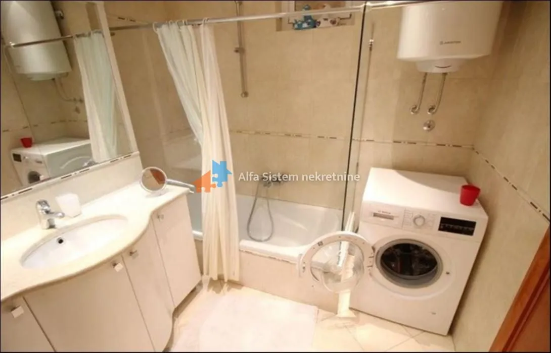 Bathroom with a sink, bathtub, and washing machine.