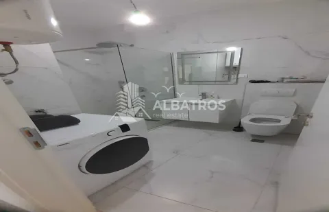Modernly equipped bathroom with a walk-in shower, washbasin, toilet, and washing machine. - image 8
