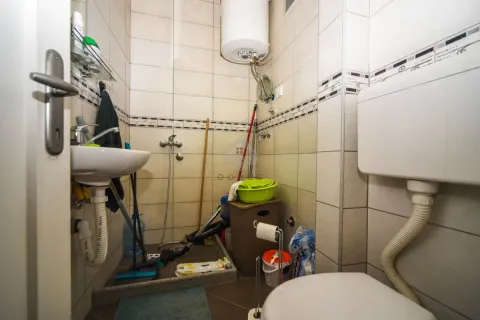 Small bathroom with a shower cabin, washbasin, and toilet. - image 5