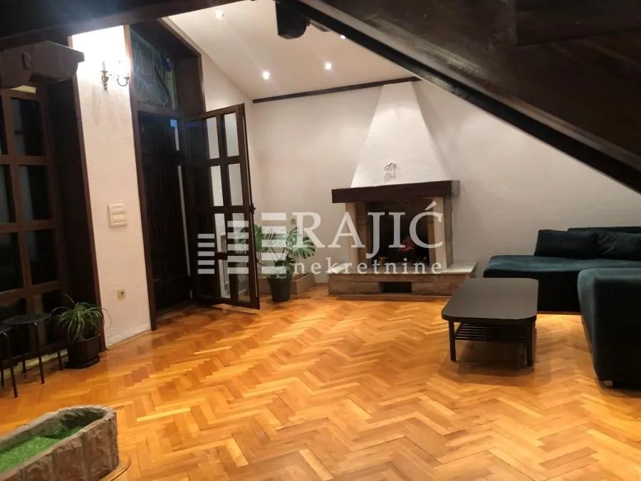 Spacious living room with a fireplace and wooden parquet flooring.