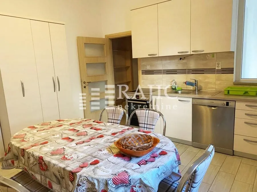 Kitchen with a dining table and built-in units.