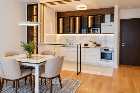 Modern kitchen with a breakfast bar and dining area in an open-plan space. - image 14