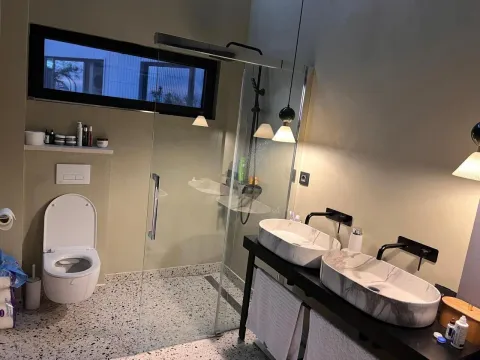 Modernly equipped bathroom with a shower cabin and two washbasins. - image 13