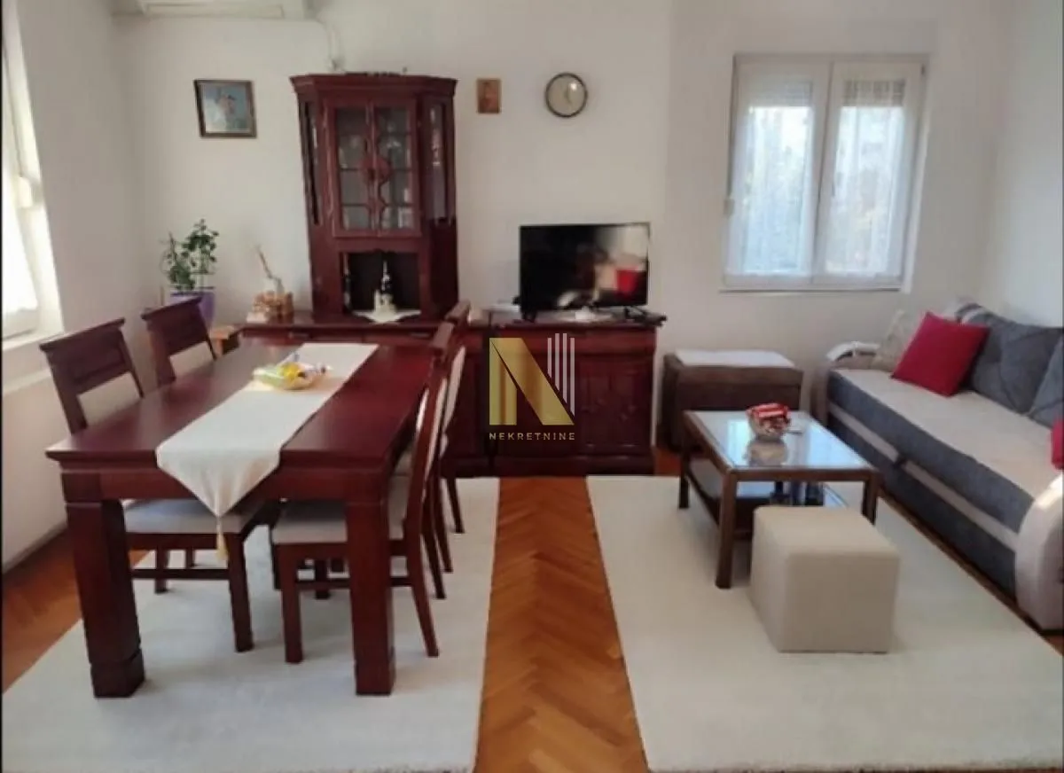 Prostrana dnevna soba sa trpezarijom i garniturom za sedenje.