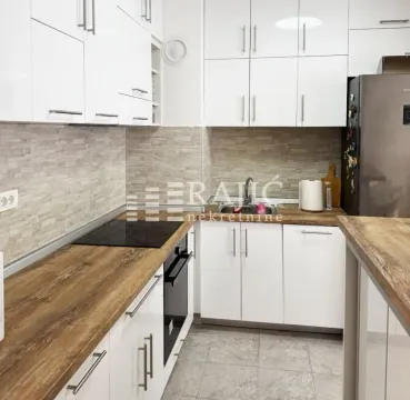 Modern kitchen with white cabinets and a wooden countertop. - image 5