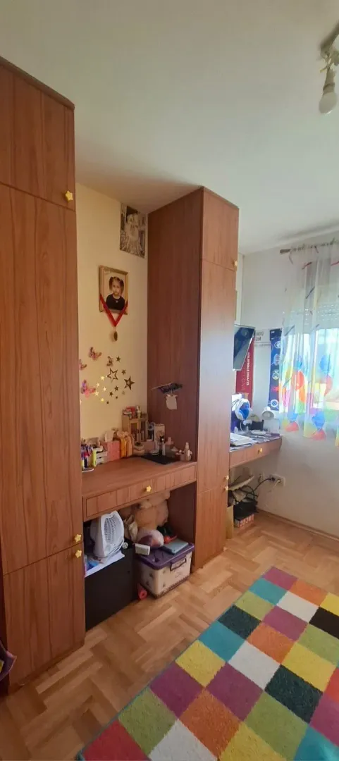 Dječija soba sa drvenim plakarima i radnim stolom.