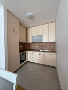 Small modern kitchen with cream cabinets and built-in appliances. - image 3