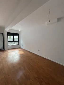 Prazna neopremljena prostorija sa drvenim podom i prozorom. - image 4